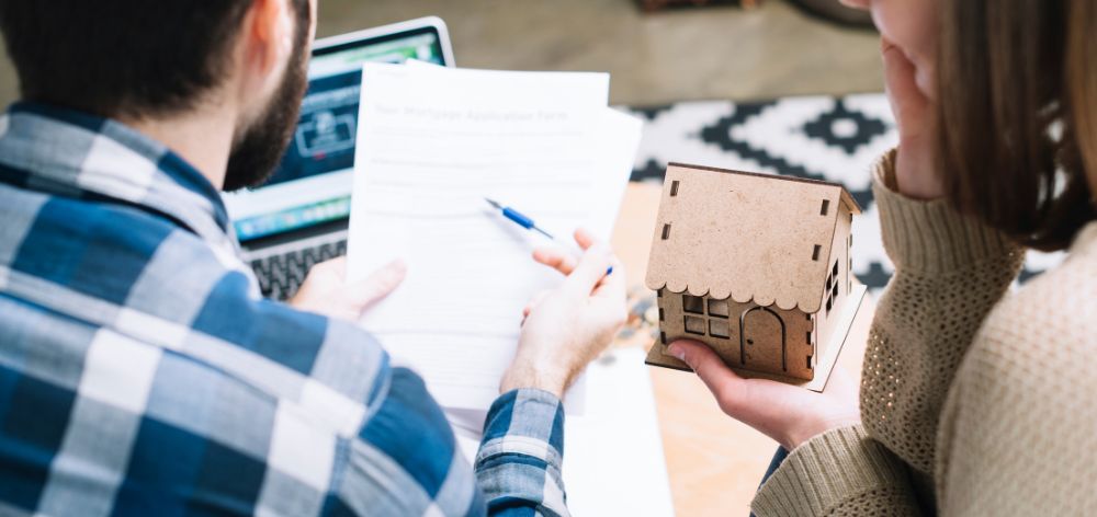 pareja revisando documentos compra casa maqueta